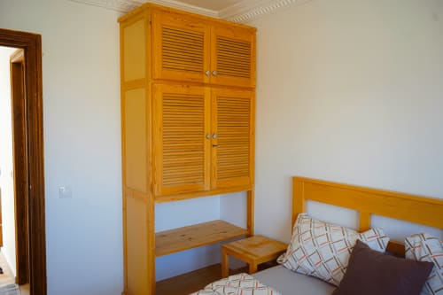 Wooden wardrobe and bed in Tassila room at Imsouane Surf Paradise hotel, Agadir
