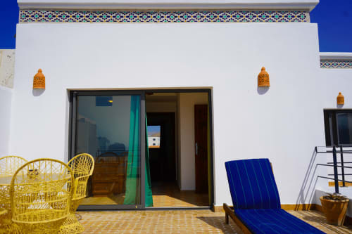 Tassila apartment terrace at Imsouane Surf Paradise with yellow seating, blue lounger, and sea view in Agadir