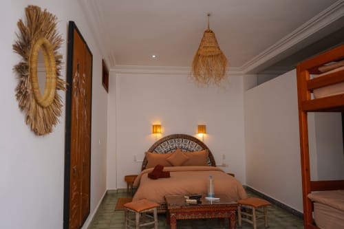 Loubana room at Imsouane Surf Paradise hotel in Agadir featuring terracotta bedding, woven pendant light, and traditional
