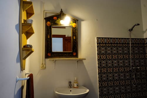 Bathroom in Loubana room at Imsouane Surf Paradise hotel with decorative mirror, sink, and shower area in Agadir, Morocco