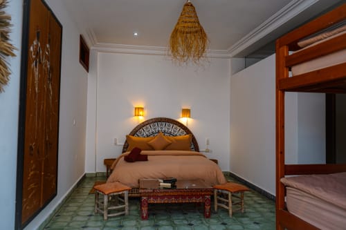 Loubana bedroom at Imsouane Surf Paradise hotel in Agadir with ornate bed, woven pendant light, and Moroccan decor