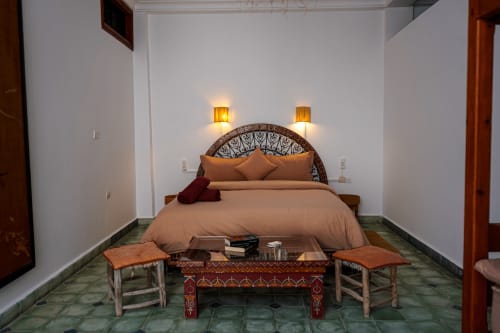 Loubana room at Imsouane Surf Paradise, Agadir with queen bed, ornate headboard, warm lighting, and ethnic décor