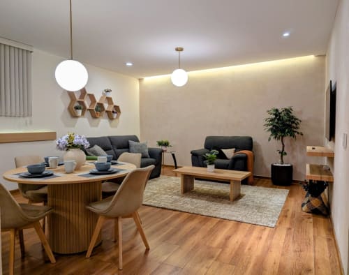 Moderna sala de estar en apartamento de Casa Donceles en Ciudad de México con comedor, asientos, piso de madera y plantas