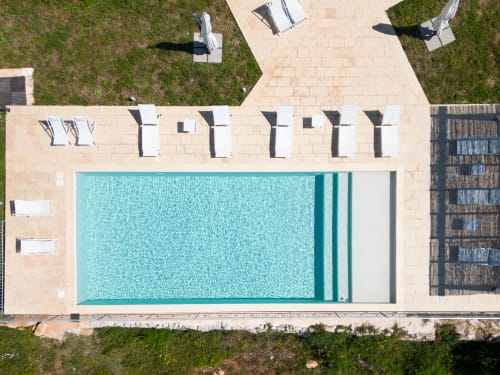 Vista aerea della piscina di Villa Casolare Treggi a Ostuni con lettini, terrazza e giardini curati