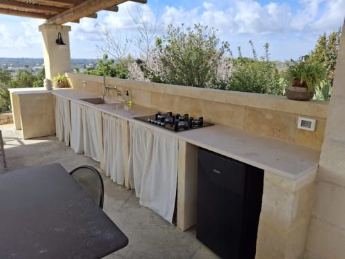 Cucina esterna con piano cottura a gas e lavello, villa Casolare Treggi a Ostuni, con vista su giardino e campagna