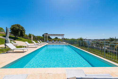 Piscina di lusso di Casolare Treggi a Ostuni con lettini, pergolato e vista sulla campagna