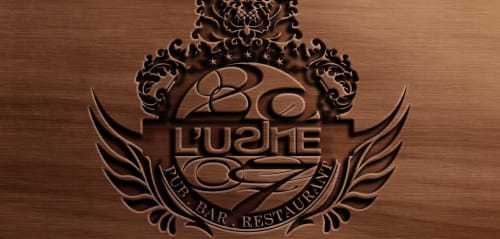 Logo en bois sculpté du bar restaurant Lushe avec détails ornementés à l'Hôtel Motelia à Moissy-Cramayel