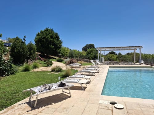Villa di lusso con piscina, lettini, pergolato e giardini curati con vista sulla campagna vicino Ostuni, Italia