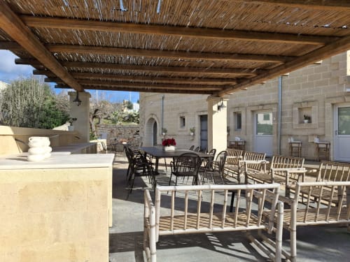 Terrazza coperta della villa Casolare Treggi a Ostuni con area pranzo, pergolato in legno e facciata in pietra