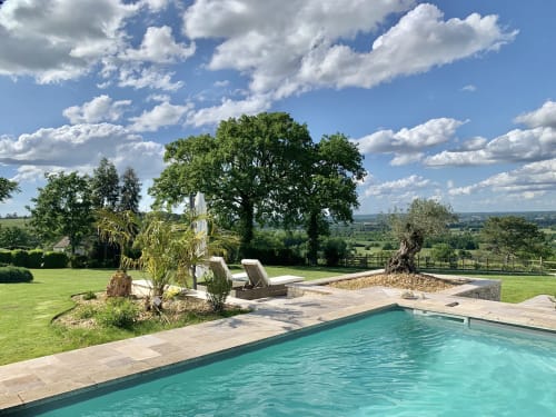Espace piscine luxueux à Parenthèse Périgourdine à Pomport, aux eaux turquoise, transats et vues sur la campagne périgourdine