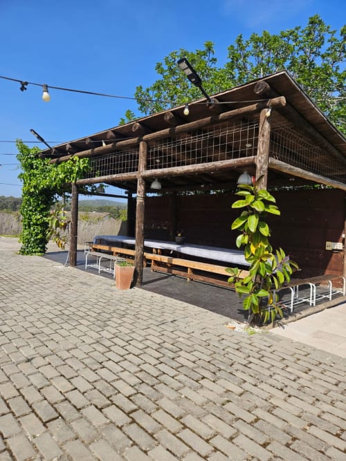 Rústico bar de jardín en Can Trabal, Olèrdola, con vigas de madera, vistas al huerto y zona de estar cubierta