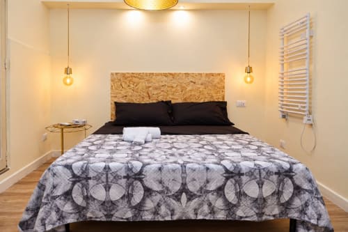 Camera moderna ad Sidra Apartments a Bari con letto queen, testata nera, illuminazione a sospensione e arredamento contemporaneo