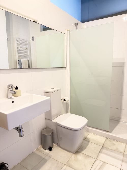 Baño moderno en apartamento de lujo en Centro, Valencia con lavabo blanco, inodoro y ducha con cristalería