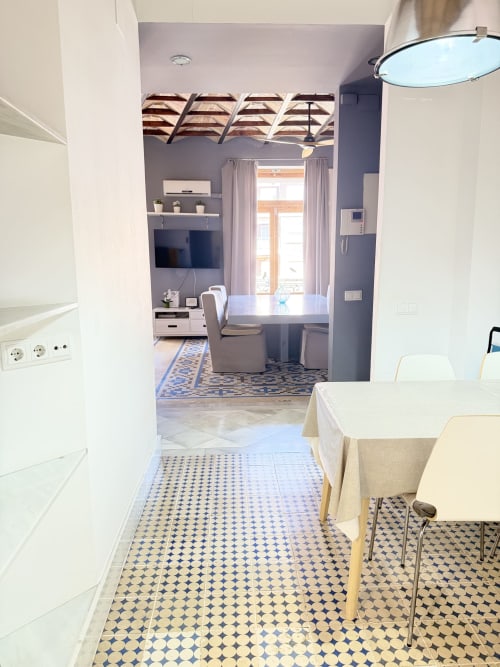 Cocina y comedor de lujo en apartamento del centro de Valencia con suelo de azulejos azul y blanco y equipamiento moderno