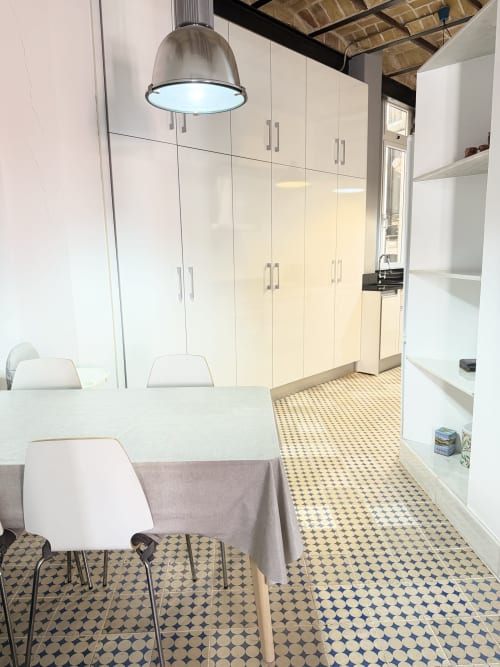 Cocina moderna del apartamento de Valencia con muebles blancos, iluminación colgante, suelo estampado y zona de comedor en Stay Gest