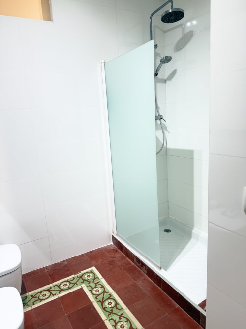 Moderno plato de ducha con alcachofa de efecto lluvia en baño de apartamento en Valencia