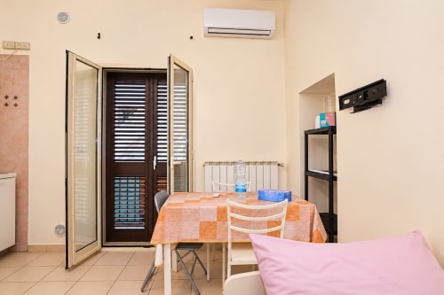 Camera Sidra Apartments Bari con tavolo da pranzo, aria condizionata, porta balcone e vista città