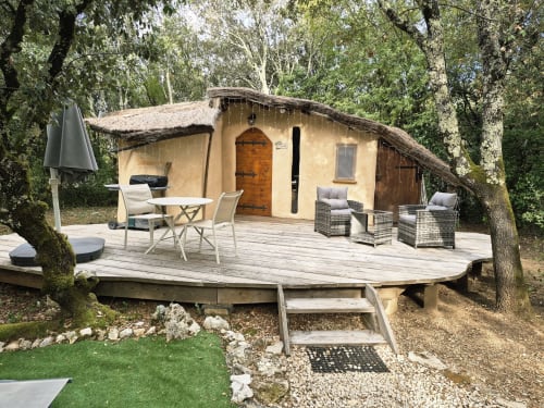 Cabane glamping rustique avec terrasse en bois, salon extérieur et cadre naturel au Domaine en Terre Happy,