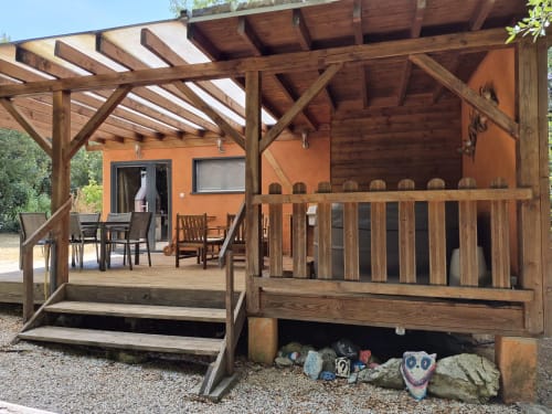 Cabane en bois aux murs orange et pergola au Domaine en Terre Happy à Labastide-de-Virac
