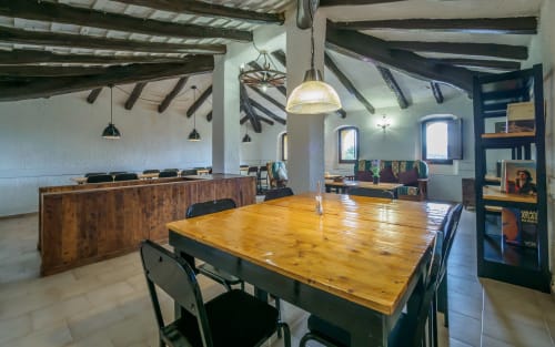 Amplio comedor con mesa de madera en villa Masias Can Trabal, con vigas vistas y vistas a la montaña