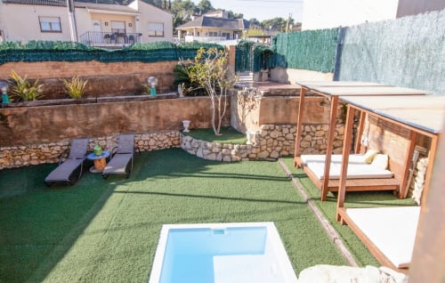 Jardín privado de villa con piscina, tumbonas, terraza de piedra y vistas a las montañas en Masias Can Trabal, Olèrdola
