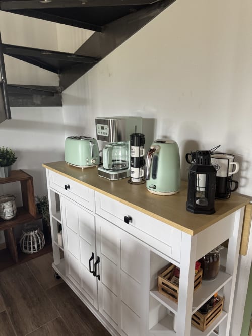 Encimera de cocina moderna con electrodomésticos verde menta y cafetera de acero inoxidable en la casa rural Cal Boix, Berga