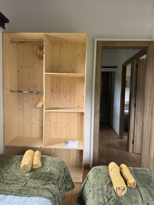 Dormitorio de la casita Cal Boix en Alberga Turisme, Berga con camas gemelas, armario de madera y acceso a vistas de montaña
