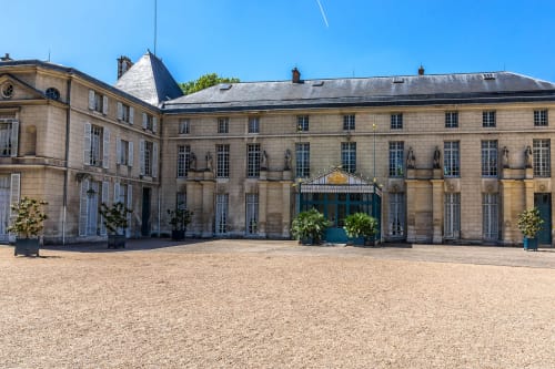 Cour de l'Hôtel le Dellys à Colombes avec architecture parisienne élégante et jardins soignés