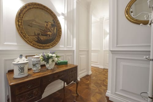 Elegante corridoio della Suite Magna Mater, Roma, con specchio ornato cornice dorata, consolle in legno con oggetti decorativi