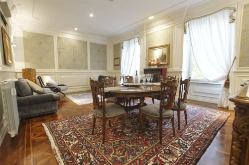 Elegante Suite Magna Mater a Roma con tavolo da pranzo ornato, arredamenti d'epoca, sedute raffinate e decori classici.