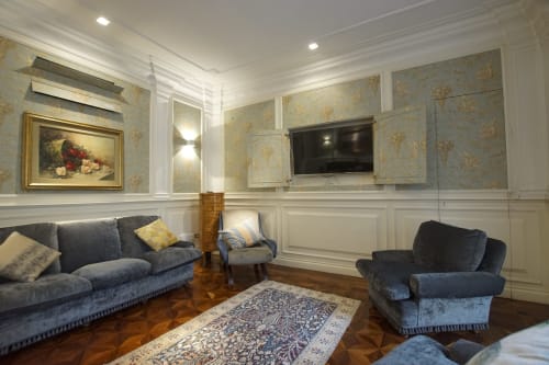 Soggiorno della Suite Magna Mater a Roma con arredi blu, camino, TV, elegante carta da parati e pavimenti in legno