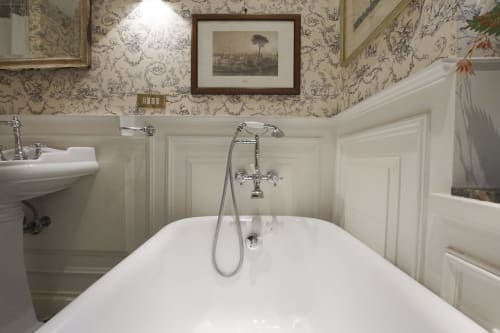 Bagno elegante nella Suite Magna Mater di Roma, con vasca freestanding bianca, rubinetteria cromata e decoro classico floreale