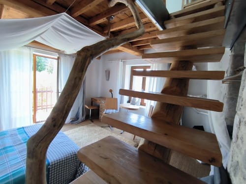 Chambre loft rustique à la Furanelle B&B Saint Etienne avec poutres apparentes, escalier en colimaçon et accès à la terrasse