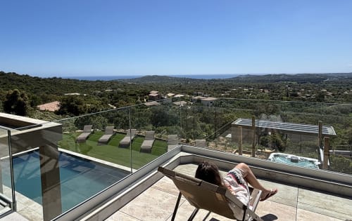 Vacancier relaxant sur la terrasse de la Villa Aria Alto avec piscine privée, spa et vue sur la Méditerranée à Pinarellu, Corse