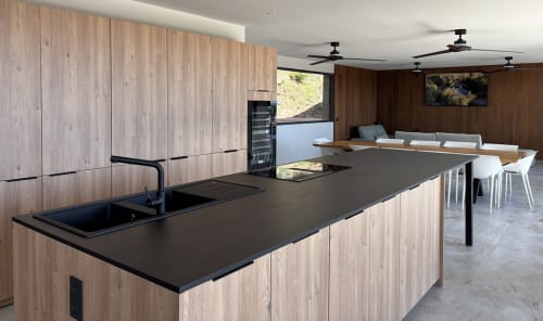 Cuisine moderne avec plan de travail noir et meubles en bois à Villa Aria Alto, Les Villas d'A Storia, Pinarellu