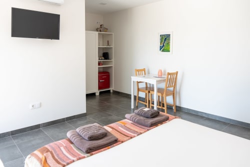 Quarto Minho at Canhoto Douro B&B, São Lourenço do Douro: spacious room with white table, wooden chairs, wall TV, and