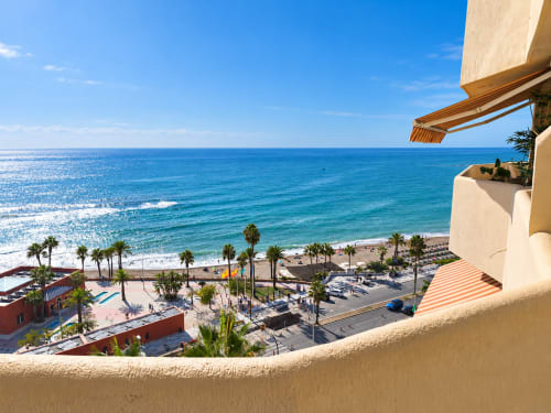 Vista frente al mar desde el balcón del apartamento VIVE Benalmádena con vistas al Mediterráneo, playa y palmeras