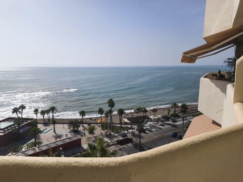 Vue du balcon sur la plage de Benalmádena avec la mer Méditerranée, palmiers et rivage sablonneux de l'appartement VIVE Benal Beach