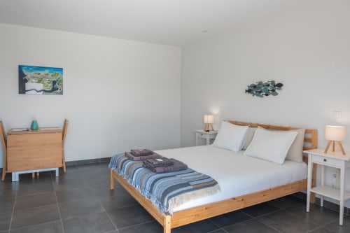 Modern bedroom at Canhoto Douro with wooden bed, white linens, and mountain views in São Lourenço do Douro