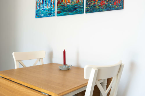Dining table with white chairs and red candle at Canhoto Douro B&B, São Lourenço do Douro, with colorful artwork above