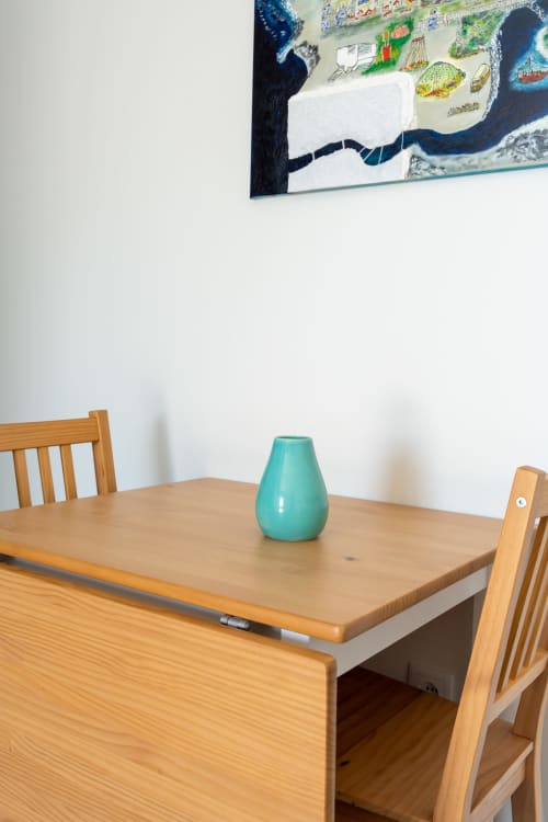 Wooden dining table with turquoise vase at Canhoto Douro bed and breakfast in São Lourenço do Douro, Portugal