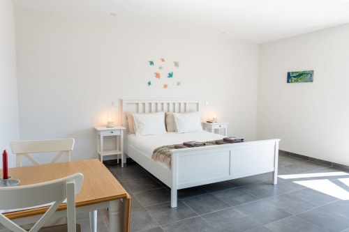 Bright bedroom at Canhoto Douro B&B with white bed, modern furnishings, and terrace view in São Lourenço do Douro
