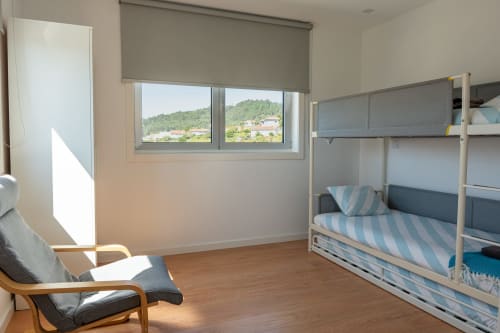Bright bedroom with bunk bed, wooden floors, and mountain views at Casa da Eira cottage in São Lourenço do Douro