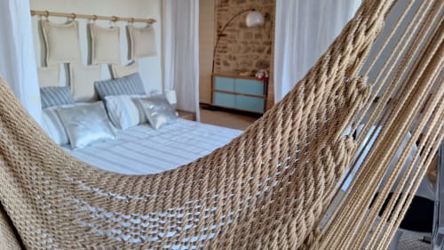 Hamac tissé dans la chambre du gîte Furanelle B&B à Saint Étienne, avec literie rayée et vue sur les montagnes