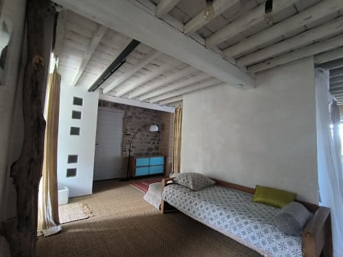 Chambre spacieuse à la Furanelle B&B Saint Etienne avec lit, poutres apparentes et vue sur les montagnes depuis le balcon