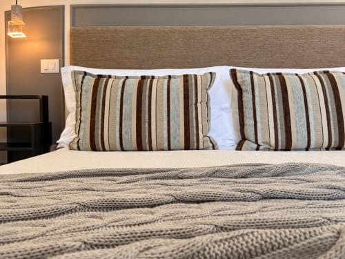 Signature Double Room at HABITARE Lecce with striped pillows, textured bedding, and warm pendant light in Salento, Italy