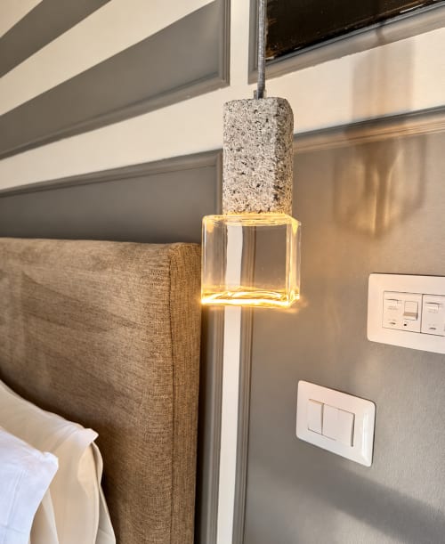 Modern pendant light with terrazzo and glass cube shade in HABITARE Lecce signature room, cream wall with light switches
