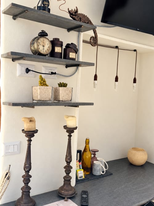 Styled shelf display in Lecce B&B with clock, candles, succulents, and decorative objects against cream wall
