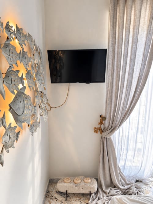 Angolo della camera d'hotel moderna presso HABITARE Lecce con TV a schermo piatto a parete, decorazione artistica con pesci, tende beige