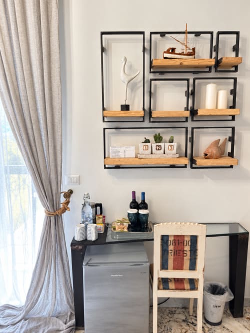 Minibar ospitalità a HABITARE Lecce con scaffali in legno, bottiglie di vino, bevande e dettagli nautici decorativi